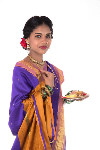 Femme indienne, culte, portrait d'une belle jeune femme avec pooja thali isolé sur mur blanc
