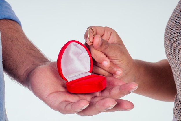 Photo femme indienne demandant à son petit ami d'obtenir un fond blanc de studio de mariage.boîte de bague cadeau rouge entendu forme.