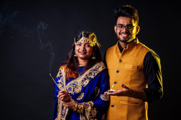 Femme indienne et homme hindou célébration fond de studio divali.