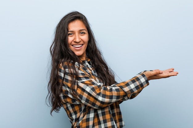 femme indienne jeune fraîche tenant un espace de copie sur une paume.