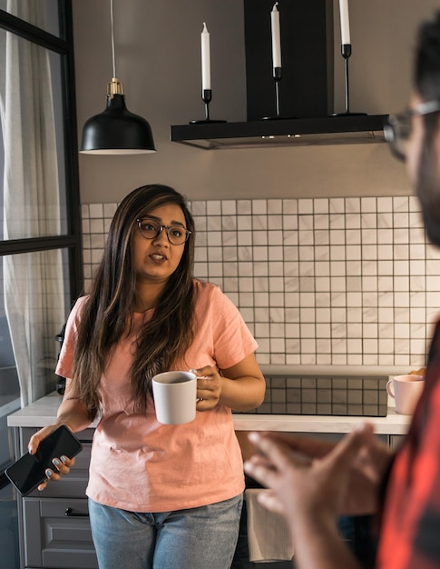 Femme indienne parlant à l'homme latino dans la cuisine Mode de vie alimentation saine concept multiethnique