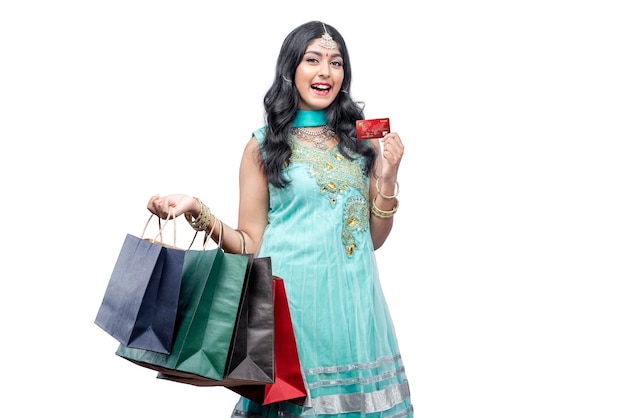 Femme indienne portant des sacs à provisions tout en tenant une carte de crédit