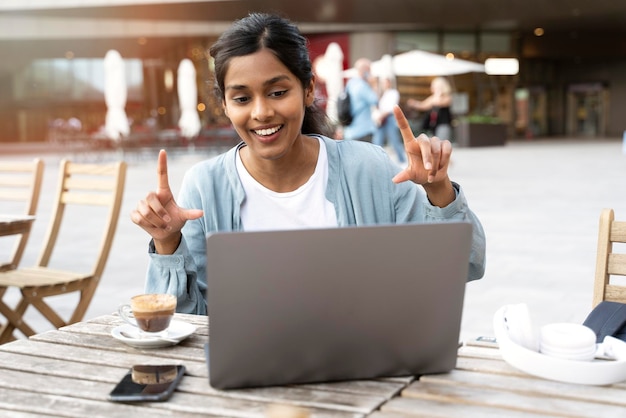 femme indienne souriante pigiste utilisant la communication d'un ordinateur portable en ligne, ayant un appel vidéo