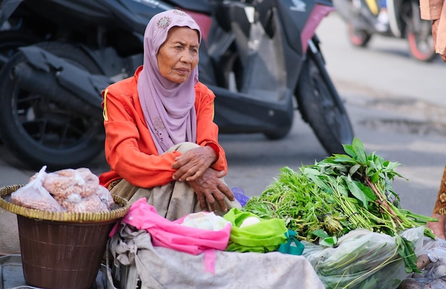 Une femme indonésienne vend des légumes sur le marché traditionnel de Yogyakarta 25 janvier 2024