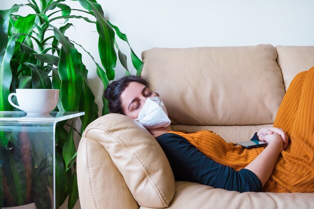 Femme infectée par la maladie du coronavirus dormant dans le canapé à la maison. Rester à la maison. Pandémie mondiale de maladie virale dans le monde 19.