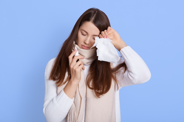 Femme infectée avec spray nasal et serviette dans les mains