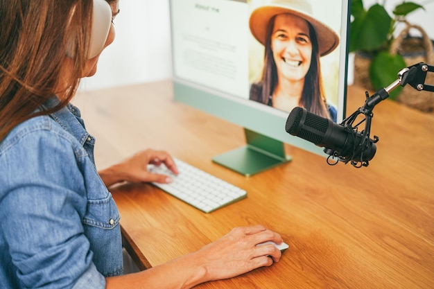 Photo femme d'influence faisant un podcast en utilisant un ordinateur à la maison concept technologique focus sur la main tenant la souris