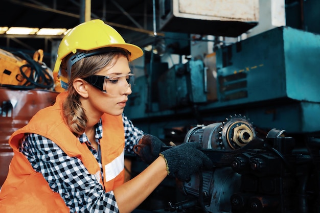 Femme d'ingénierie fixant la machine dans l'entrepôt