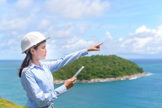 Femme ingénieur travaillant en bord de mer portant un casque de protection x9