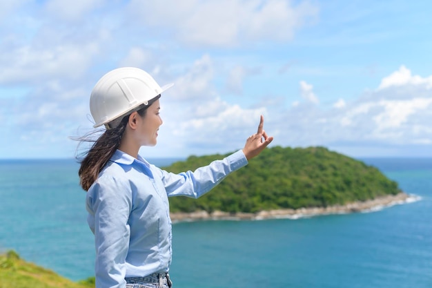 Femme ingénieur travaillant en bord de mer portant un casque de protection x9