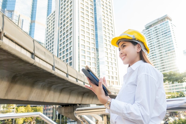 Femme d'ingénieur travaille dans le contexte de la ville en plein air