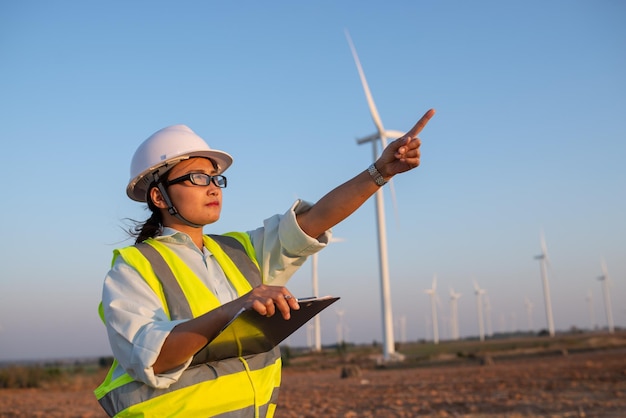 Femme ingénieure travaillant et tenant le rapport à la centrale éolienne de la centrale électrique sur la montagneThaïlande