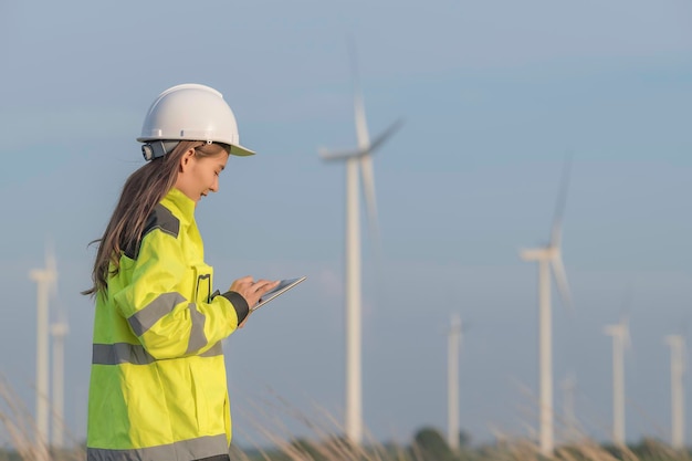 Femme ingénieure travaillant et tenant le rapport à la centrale éolienne de la centrale électrique sur la montagneThaïlande