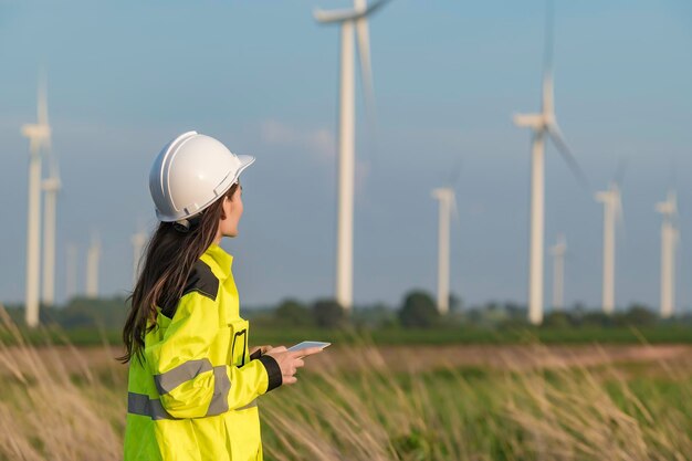 Femme ingénieure travaillant et tenant le rapport à la centrale éolienne de la centrale électrique sur la montagneThaïlande