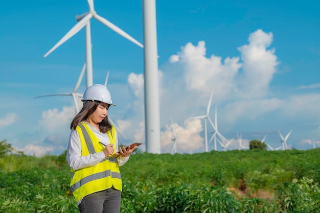 Femme ingénieure travaillant et tenant le rapport à la centrale éolienne de la centrale électrique sur la montagneThaïlande