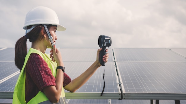 Femme ingénieure utilisant un imageur thermique pour vérifier la température du panneau solaire