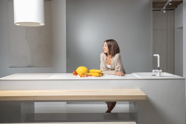 Femme avec des ingrédients alimentaires sains à la cuisine