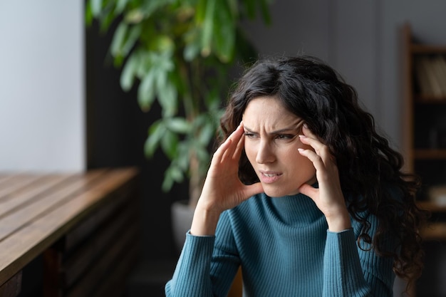 Une femme inquiète ayant des pensées anxieuses a souligné une jeune femme souffrant de maux de tête anxieux