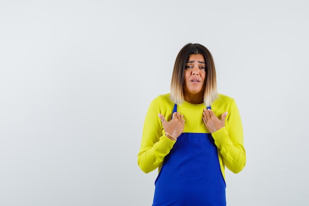 La Femme Inquiète Se Montre Avec Les Mains Avec La Main Sur Fond Blanc