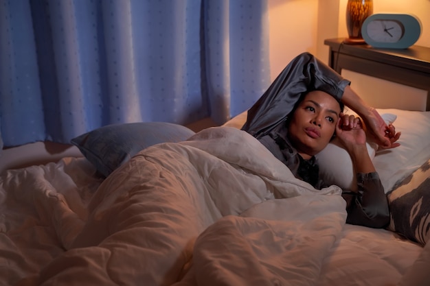 Photo une femme insomniaque a atteint le réveil à 2 heures du matin. causé par le stress du chômage