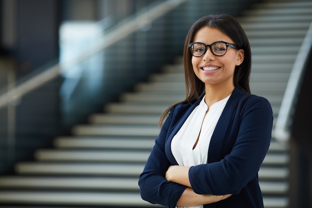 Femme intelligente souriante travaillant dans une entreprise prospère