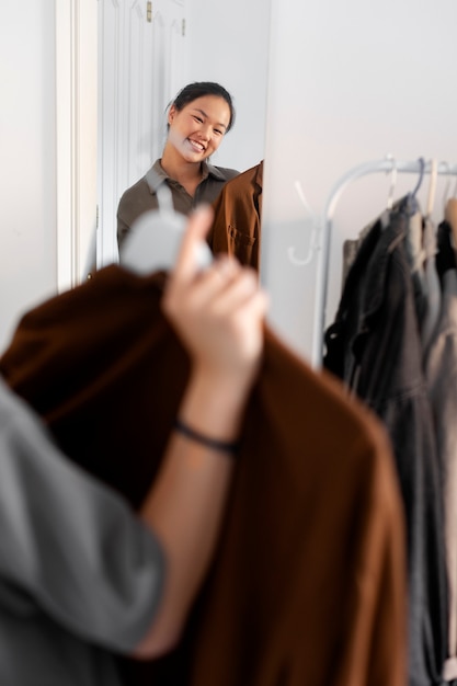 Femme à l'intérieur essayant des vêtements