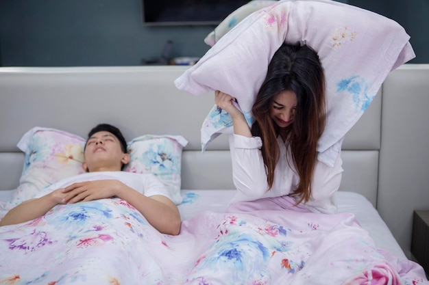 Photo une femme irritée avec son mari qui ronfle.