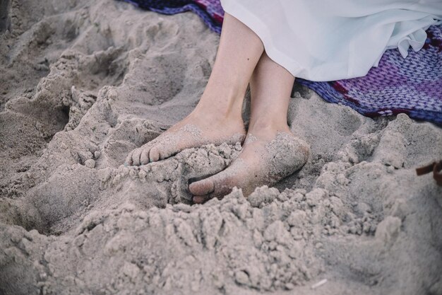 Femme jambes bronzées sur la plage de sable Travel concept Happy feet in tropical