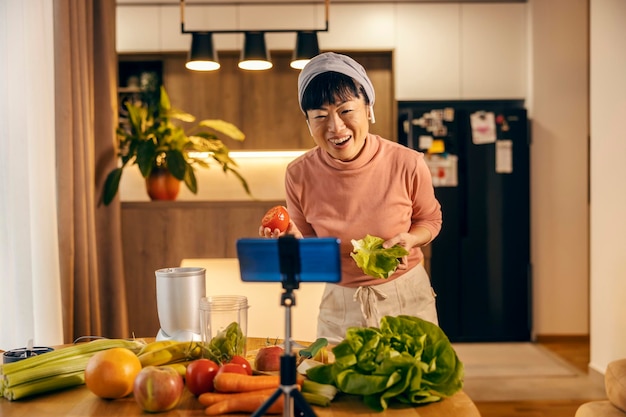 Une femme japonaise d'âge moyen est en direct en train de cuisiner de la nourriture saine.