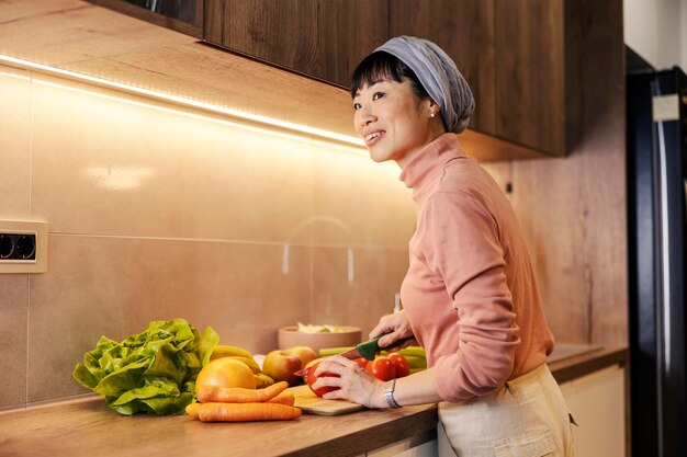 Une femme japonaise d'âge moyen prépare un déjeuner sain dans la cuisine.