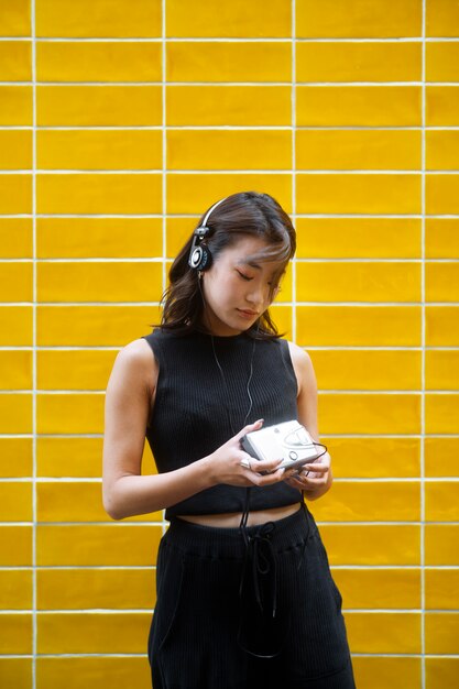 Femme japonaise de coup moyen avec des écouteurs