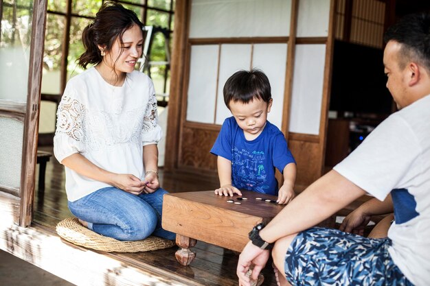 Femme japonaise homme et petit garçon assis sur le sol jouant Go