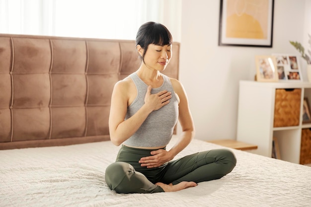 Photo une femme japonaise en position de lotus pratique le yoga dans la chambre.