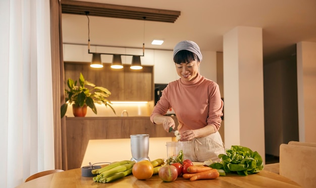 Une femme japonaise prépare un smoothie sain à la maison