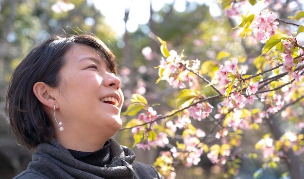 Femme japonaise avec un sourire et des fleurs de cerisier