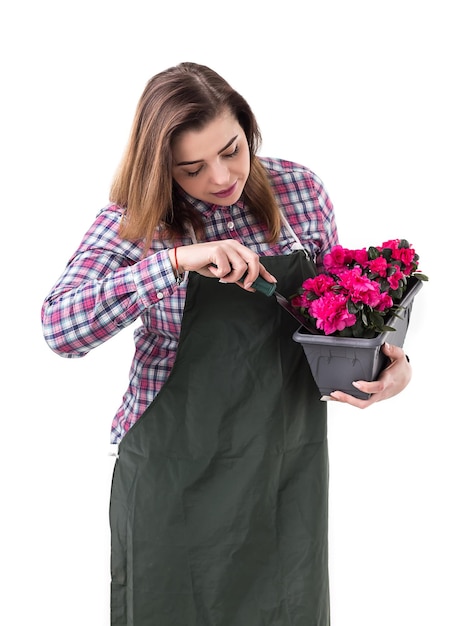 Femme jardinier professionnel ou fleuriste en tablier tenant des fleurs dans un pot et des outils de jardinage isolés sur fond blanc Espace de copie