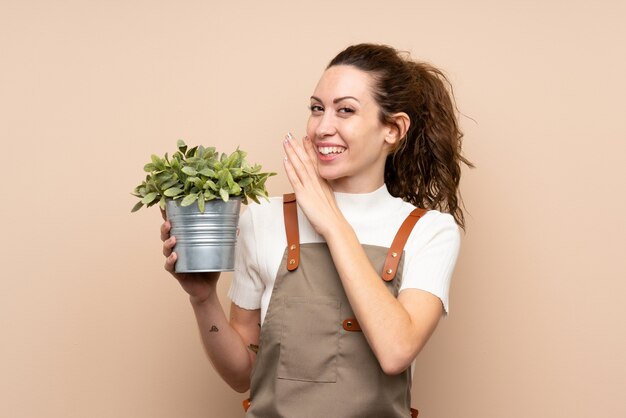 Femme jardinier tenant une plante murmurant quelque chose