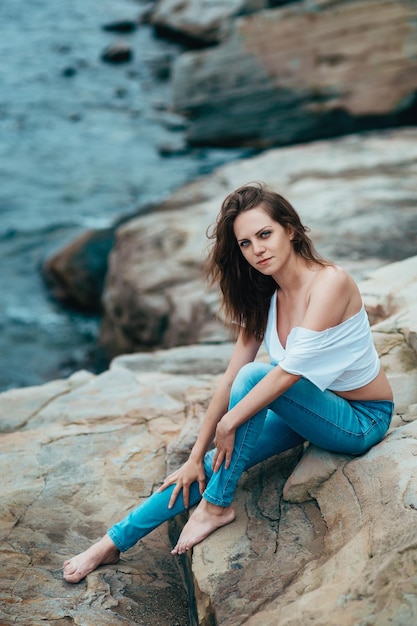 Femme en jeans près de la mer