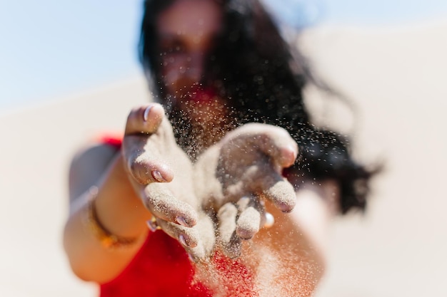 Une femme jetant du sable dans le désert