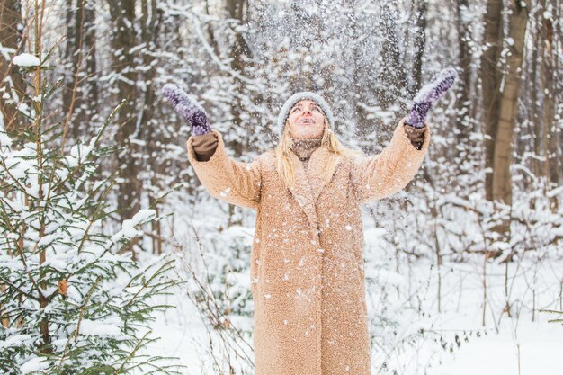 Femme jette la neige, le plaisir et le concept d'hiver.