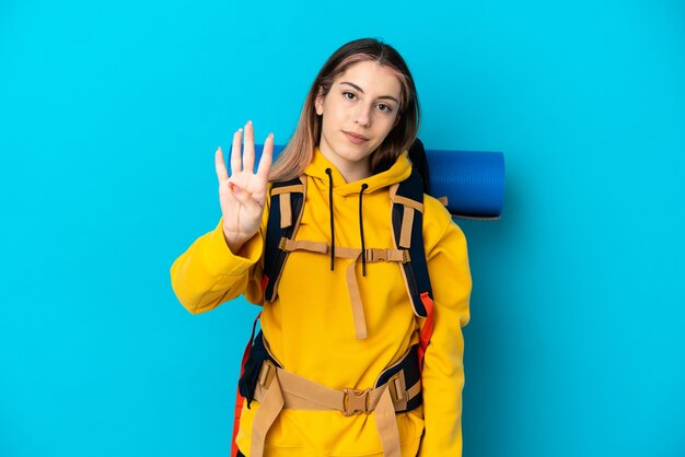 Femme jeune alpiniste avec un gros sac à dos isolé