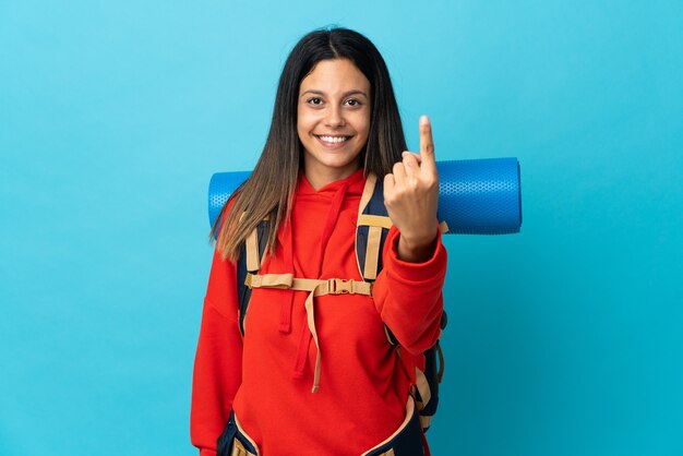 Femme jeune alpiniste avec sac à dos faisant le geste à venir