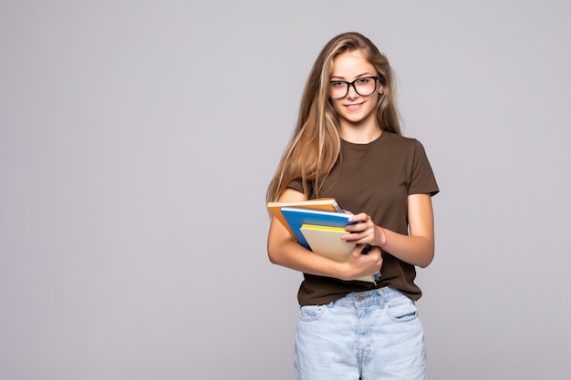 Photo femme jeune étudiante avec livre isolé sur mur blanc.