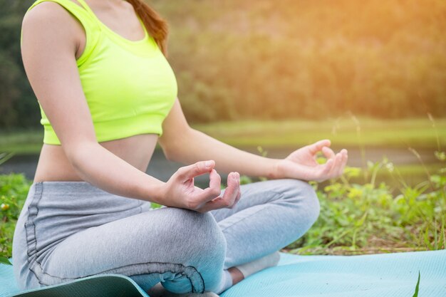 Femme jeune de fitness pratiquant le yoga sur le terrain