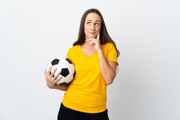 Femme jeune joueur de football sur fond blanc isolé ayant des doutes et de la pensée