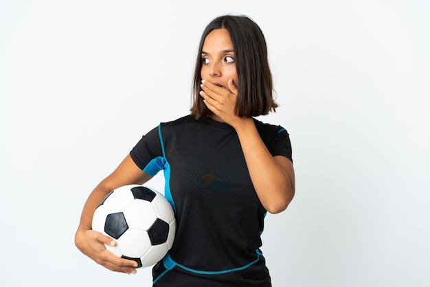 Femme jeune joueur de football isolé sur fond blanc faisant un geste de surprise tout en regardant sur le côté