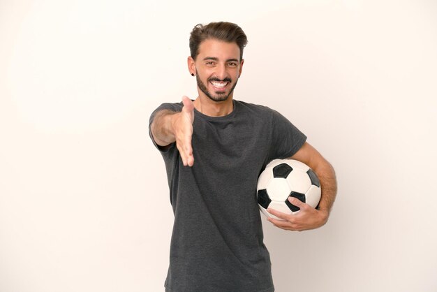 Femme jeune joueur de football isolé sur fond blanc se serrant la main pour conclure une bonne affaire