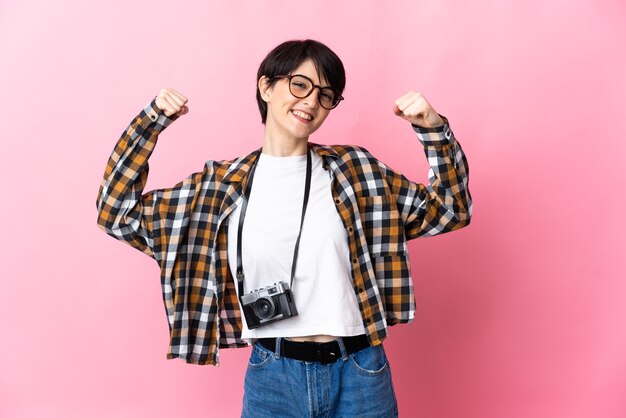 Femme jeune photographe isolée sur mur rose faisant un geste fort