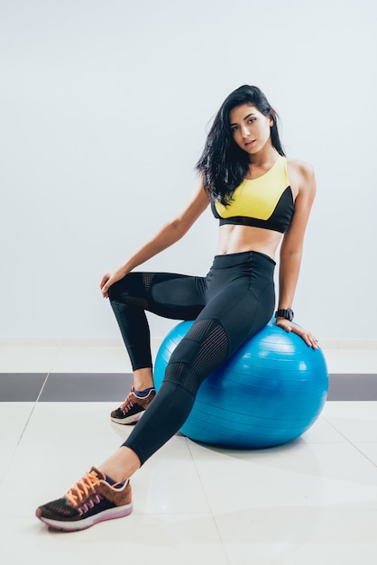 Femme jeune de remise en forme avec fitball bleu.