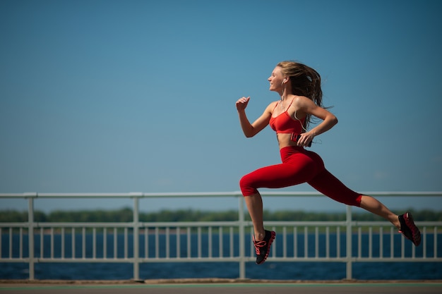 Femme jeune de remise en forme qui court sur la côte. Le concept d&#39;un mode de vie sain